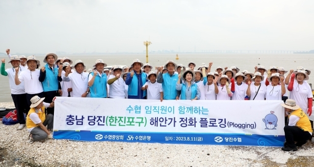 Sh수협은행은 지난 11일 충남 당진 한진포구에서 수협중앙회와 공동으로 ‘해안가 환경정화 플로깅’ 캠페인을 펼쳤다. 캠페인 활동에 앞서 모든 참가자가 함께 기념촬영을 하고 있다./Sh수협은행