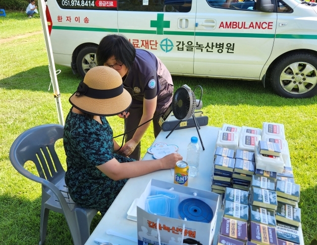 갑을녹산병원이 지난 26일 부산시 강서구 행사 「여름밤의 낭만, 온가족이 함께하는 2023 찾아가는 영화관」에 구급차 및 의료부스를 지원하고 의료진이 행사에 참여한 지역민의 건강상태를 살피고 있다./갑을녹산병원