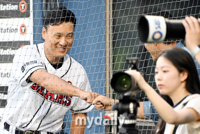 두산 이승엽 감독이 경기 전 만난 탤런트 윤태영과 하이파이브를 하고 있다.