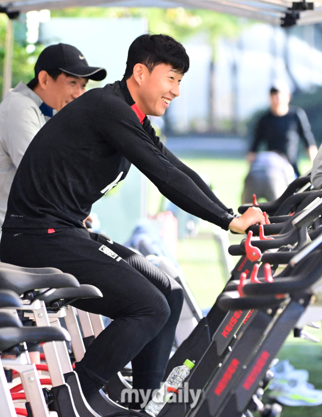 손흥민이 사이클을 타면서 동료들의 훈련을 지켜보고 있다.