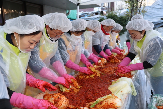 24일 서울 중구 대한적십자사 서울 중앙봉사관에서 열린 ‘사랑의 김장나눔’ 행사에서 윤해진 NH농협생명 대표(왼쪽 두번째)，권영규　대한적십자사　서울특별시지사　회장(왼쪽　다섯번째)와 임직원봉사단이 김장을　담그고 있다./NH농협생명