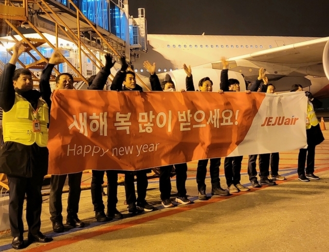 김이배 제주항공 대표이사(사진 왼쪽에서 여섯번째)와 임직원들이 인천국제공항에서 새해 첫 출발편탑승객에게 인사를 하고 있다./제주항공