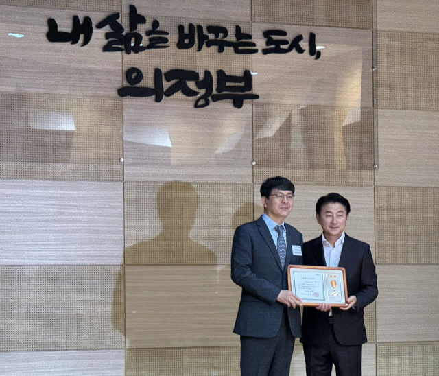 경륜경정총괄본부 김성훈 사업기획실장(왼쪽)이 2일 김동근 의정부시장으로부터 성실납세 인증서를 받고 있다. /경륜경정총괄본부 제공