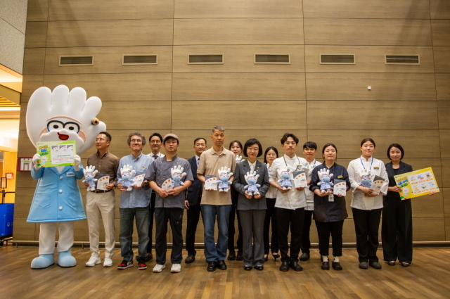 27일 아워홈 한식소담길 인천공항 제1터미널점에서 진행된 위생등급제 ‘매우 우수’ 획득 기념 현판식에서 오유경 식약처장(왼쪽 7번째)과 직원들이 기념촬영을 진행하고 있다./아워홈