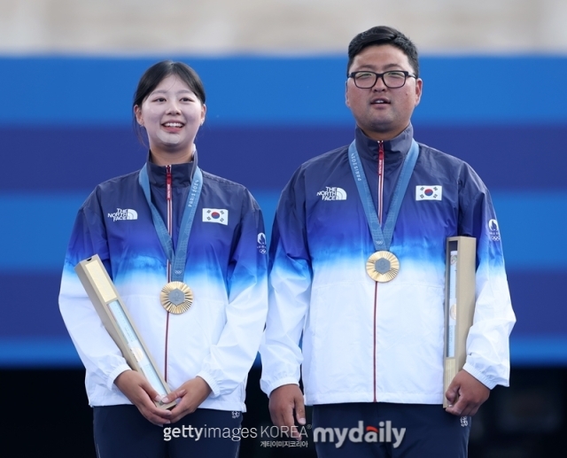 김우진(오른쪽)과 임시현이 양궁 혼성 단체점 금메달을 획득한 뒤 시상식에서 기념사진을 찍고 있다./게티이미지코리아