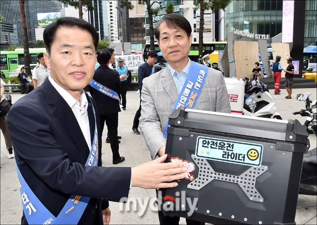 27일 고광재 안전보건공단 서울광역본부장(왼쪽)은 양승준 고용노동부 서울강남지청장과 함께 서울 강남구에 위치한 강남스퀘어 광장(강남역 11번 출구)에서 이동근로자 대상 민·관·경 합동 안전 캠페인을 실시했다. 사진은 이동근로자 오토바이에 안전 스티커를 붙이는 모습./송일섭 기자