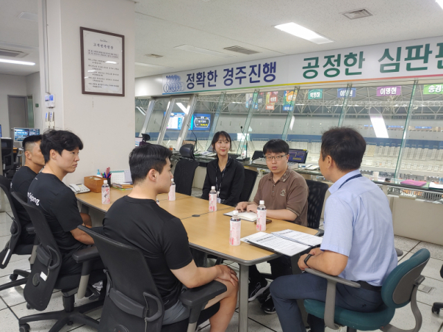 경륜 선수(왼쪽 세 명)가 심판판정 과정에 대한 설명을 듣고 있다. /경륜경정총괄본부 제공