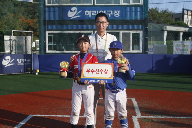 동대문구마인볼유소년야구단 천서빈(아래 왼쪽) 이상근 대한유소년야구연맹 회장으로부터 우수선수상을 받았다. /대한유소년야구연맹 제공