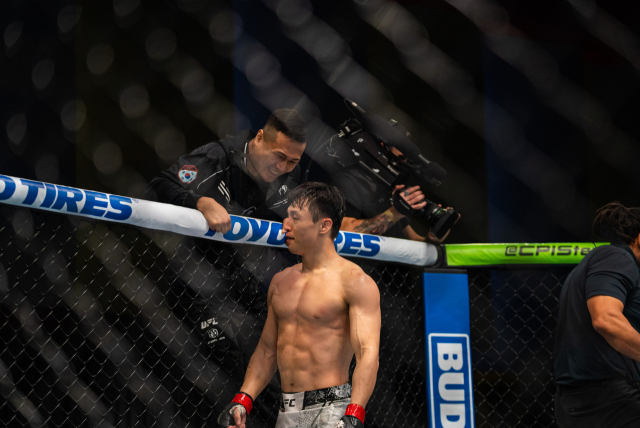 최두호(아래)가 알지오를 꺾은 후 정찬성의 축하를 받고 있다. /UFC 제공