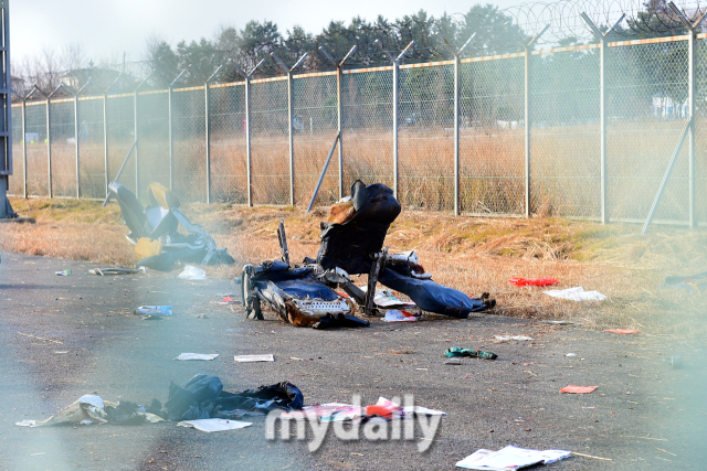 지난 29일 오전 전남 무안국제공항으로 착륙하던 방콕발 제주항공 2216편이 랜딩기어 고장으로 동체 착륙을 하던 중 활주로를 이탈해 울타리 외벽과 충돌한 뒤 큰 폭발 했다. 사고 하루가 지난 30일 오전 공항 외곽 철조망 너머까지 비행기 잔해물들이 떨어졌다. /곽경훈 기자