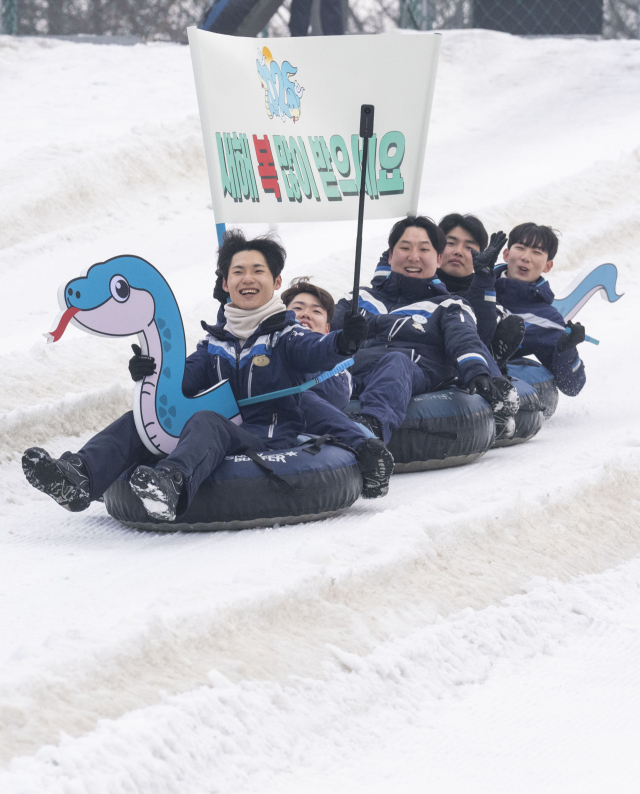 22일 에버랜드 눈썰매장 스노우 버스터에서 직원들이 을사년(乙巳年) 푸른 뱀의 해를 맞아 특별히 연출된 눈썰매를 타고 내려오며 ‘새해 복 많이 받으세요’가 적힌 깃발을 흔들고 있다. /삼성물산