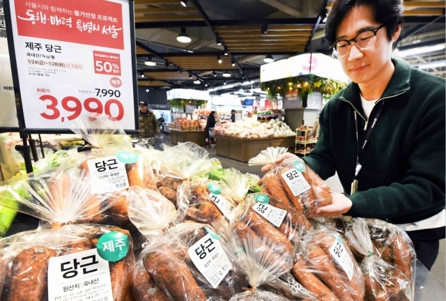 권오상 홈플러스 채소 바이어가 서울시와 함께하는 물가안정 프로젝트 상품인 반값 행사 당근을 선보이고 있다. /홈플러스