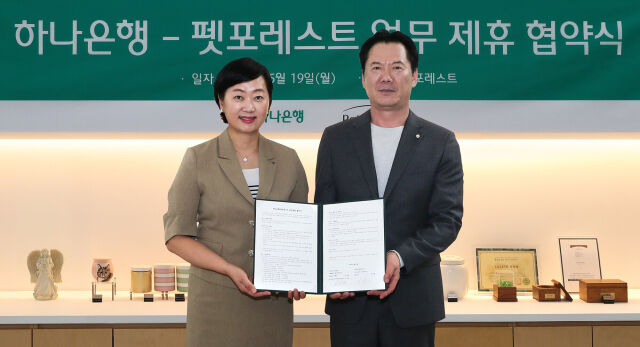 하나은행은 지난 19일 반려동물 장례서비스 제공 업체인 펫포레스트와 수신 VIP 손님 지원을 위한 업무협약을 체결했다. 이날 협약식에 참석한 이은정 하나은행 하나더넥스트본부장(왼쪽)이 이상흥 펫포레스트 대표와 함께 협약서를 들고 기념 촬영을 하고 있다./하나은행