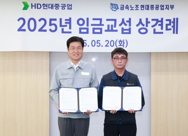 20일 HD현대중공업 울산본사에서 열린 '2025년 임금교섭 상견례'에서 이상균 HD현대중 사장(왼쪽)과 백호선 금속노조 현대중공업지부장이 임금교섭 기본사항 합의서를 들고 기념 촬영을 하고 있다. /HD현대중공업