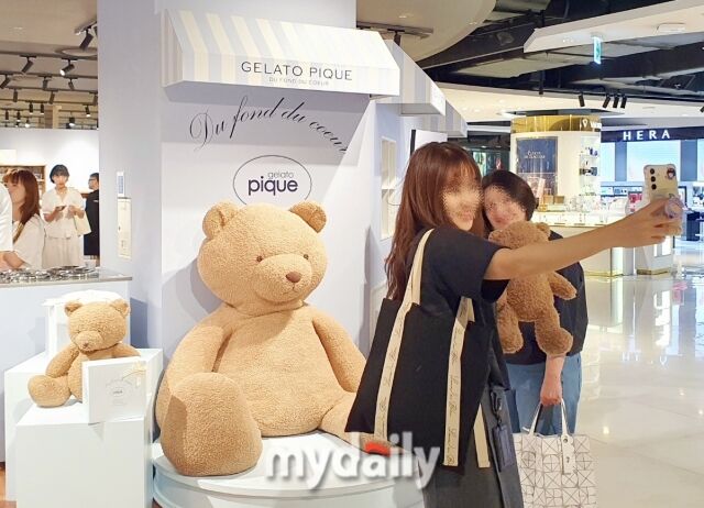 팝업스토어 입구에서 방문객이 대형 곰돌이 인형을 배경으로 인증샷을 찍고 있다. /방금숙 기자